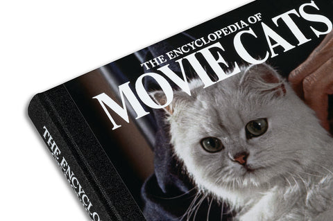Close-up of a page from The Encyclopedia of Movie Cats by A24, showing detailed illustrations of famous on-screen feline characters.